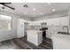 Bright kitchen with white cabinets, an island, modern appliances, and gray wood floors at 20919 E Desert Hills Blvd, Queen Creek, AZ 85142