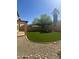 Spacious backyard featuring lush artificial grass, mature trees, and a retaining border; ideal for outdoor enjoyment and low maintenance at 2114 N 94Th Ave, Phoenix, AZ 85037