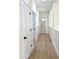 Hallway with light wood flooring, white doors, and recessed lighting at 2114 N 94Th Ave, Phoenix, AZ 85037