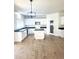 Bright kitchen with an island, white cabinets, modern lighting, and dark countertops at 2114 N 94Th Ave, Phoenix, AZ 85037