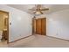 Cozy carpeted bedroom with a ceiling fan, closet and door to bathroom at 2138 W Northview Ave, Phoenix, AZ 85021