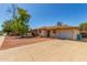 Charming single-story home with gravel yard and mature trees under a clear blue sky at 2138 W Northview Ave, Phoenix, AZ 85021
