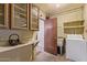 Functional laundry room with utility sink, washer, and storage cabinets at 2138 W Northview Ave, Phoenix, AZ 85021