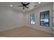 Bright bedroom with a ceiling fan, carpeted floors, and views out the windows at 2859 E Los Altos Rd, Gilbert, AZ 85297