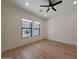 Well-lit bedroom featuring hardwood floors, a ceiling fan, and two bright windows at 2859 E Los Altos Rd, Gilbert, AZ 85297
