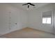Simple bedroom with neutral carpet, a ceiling fan, and a large window at 2859 E Los Altos Rd, Gilbert, AZ 85297