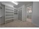 Spacious closet featuring custom shelving and a view to an ensuite bathroom at 2859 E Los Altos Rd, Gilbert, AZ 85297