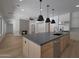 Kitchen island with a sink, dishwasher, and light wood colored paneling at 2859 E Los Altos Rd, Gilbert, AZ 85297