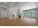 Open-concept living room with hardwood floors, a modern chandelier, and a cozy fireplace at 2859 E Los Altos Rd, Gilbert, AZ 85297
