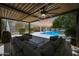 Cozy outdoor patio with comfortable seating overlooking a refreshing pool and backyard at 2859 E Los Altos Rd, Gilbert, AZ 85297