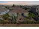 Aerial view of a home with a brick-paved patio, lush desert landscaping, and outdoor dining for relaxing outdoor living at 36130 N Quiros Dr, Queen Creek, AZ 85143