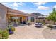 Relaxing back patio features a brick-paved area with an outdoor dining set and sliding door entry to the home at 36130 N Quiros Dr, Queen Creek, AZ 85143