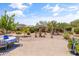 Beautiful backyard boasts desert landscaping, a charming fountain, and a dining set for outdoor enjoyment at 36130 N Quiros Dr, Queen Creek, AZ 85143