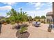 Expansive backyard featuring desert landscaping, a tranquil fountain, and an inviting outdoor dining area at 36130 N Quiros Dr, Queen Creek, AZ 85143