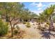 Idyllic backyard with lush desert landscaping, a relaxing fountain, and a charming outdoor dining space at 36130 N Quiros Dr, Queen Creek, AZ 85143