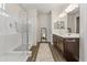 Bright bathroom featuring double sinks, modern lighting, a walk-in shower, and neutral colors at 36130 N Quiros Dr, Queen Creek, AZ 85143
