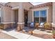 Charming front porch featuring a seating area and an ornate decorative metal security front door at 36130 N Quiros Dr, Queen Creek, AZ 85143