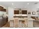 Well-lit kitchen features a large island with seating, dark cabinets, stainless steel appliances, and tile flooring at 36130 N Quiros Dr, Queen Creek, AZ 85143