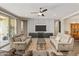 Cozy living room with plush seating, a modern TV, a ceiling fan, and wood-look flooring at 36130 N Quiros Dr, Queen Creek, AZ 85143