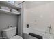 Bright bathroom featuring built-in shelves and a soaking tub with tile surround and modern fixtures at 3955 E Fox Cir, Mesa, AZ 85205