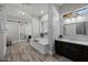 Serene bathroom featuring a soaking tub, dual vanities, and stylish wood-look tile flooring, perfect for relaxation at 3955 E Fox Cir, Mesa, AZ 85205