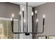 Close-up of a modern, black chandelier with exposed bulbs in a dining space at 3955 E Fox Cir, Mesa, AZ 85205
