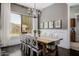 Dining area with wooden table, seating for eight, and a modern chandelier near a window at 3955 E Fox Cir, Mesa, AZ 85205