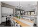 Spacious dining area featuring a wooden table, white chairs, and modern chandelier, adjacent to the kitchen at 3955 E Fox Cir, Mesa, AZ 85205