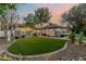 Charming single-story house with a well-manicured lawn, mature trees, and a walkway at 3955 E Fox Cir, Mesa, AZ 85205