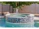 Close up of sparkling hot tub with custom tilework, seamlessly integrated into the pool area for relaxation at 3955 E Fox Cir, Mesa, AZ 85205