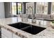 Close up of kitchen island featuring a dark composite sink, a granite countertop, and stainless steel faucets at 3955 E Fox Cir, Mesa, AZ 85205