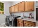 Close-up of a laundry room featuring modern washer and dryer, plus overhead cabinets at 3955 E Fox Cir, Mesa, AZ 85205