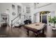 Open-concept living room featuring a grand staircase, piano, pool table, and soaring ceilings at 3955 E Fox Cir, Mesa, AZ 85205
