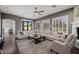 Bright living room featuring a large sectional sofa, dark floors, and large windows with shutters at 3955 E Fox Cir, Mesa, AZ 85205