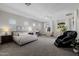 Expansive main bedroom showcasing plush carpeting, a cozy seating area, and large windows for natural light at 3955 E Fox Cir, Mesa, AZ 85205