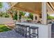 Outdoor kitchen with stainless steel grill, bar seating, and patio cover at 3955 E Fox Cir, Mesa, AZ 85205