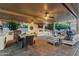 Luxurious outdoor living space featuring a fireplace, outdoor kitchen, seating area, and pool at 3955 E Fox Cir, Mesa, AZ 85205