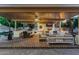 Spacious outdoor living area with fireplace, dining space, and comfortable seating under a covered patio at 3955 E Fox Cir, Mesa, AZ 85205