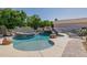 Private backyard pool with rock waterfall and slide feature, surrounded by lush landscaping at 3955 E Fox Cir, Mesa, AZ 85205