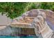 Backyard pool slide with natural rock features and a gentle waterfall, perfect for backyard fun and entertainment at 3955 E Fox Cir, Mesa, AZ 85205