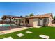 Home exterior featuring a pool, covered patio, and artificial grass at 4134 W Camino Acequia --, Phoenix, AZ 85051