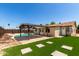 Home exterior featuring a pool, covered patio, and artificial grass at 4134 W Camino Acequia --, Phoenix, AZ 85051