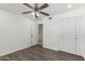 Bright bedroom features modern ceiling fan, wood-look floors, and white closets for ample storage at 4134 W Camino Acequia --, Phoenix, AZ 85051