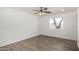 Minimalist bedroom with modern ceiling fan, wood-look floors, and a bright window at 4134 W Camino Acequia --, Phoenix, AZ 85051