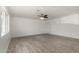 Large living room with modern ceiling fan, white walls, and wood-look tile flooring at 4134 W Camino Acequia --, Phoenix, AZ 85051