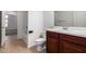 Bathroom features a dark wood vanity, tile floor, and a toilet with white seat at 4241 E Bonanza Rd, Gilbert, AZ 85297