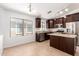 The kitchen features stainless steel appliances, dark wood cabinets, and beige countertops at 4241 E Bonanza Rd, Gilbert, AZ 85297