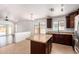Kitchen with stainless steel appliances, tile floor, island, and dark wood cabinets at 4241 E Bonanza Rd, Gilbert, AZ 85297