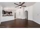 An open living space with dark wood floors, an ceiling fan, and a partial view of the kitchen at 4241 E Bonanza Rd, Gilbert, AZ 85297