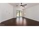 An empty room with dark wood flooring, a ceiling fan, and sliding glass doors at 4241 E Bonanza Rd, Gilbert, AZ 85297